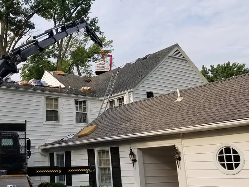 Crane delivering shingles onto roof